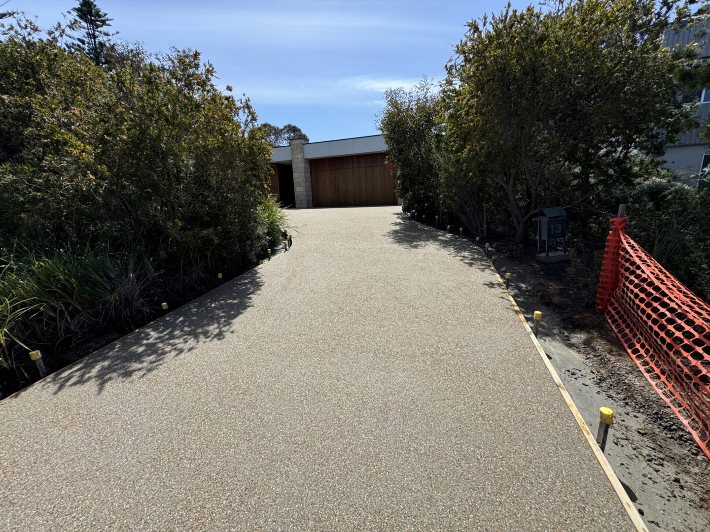 Newly paved driveway with surrounding trees.